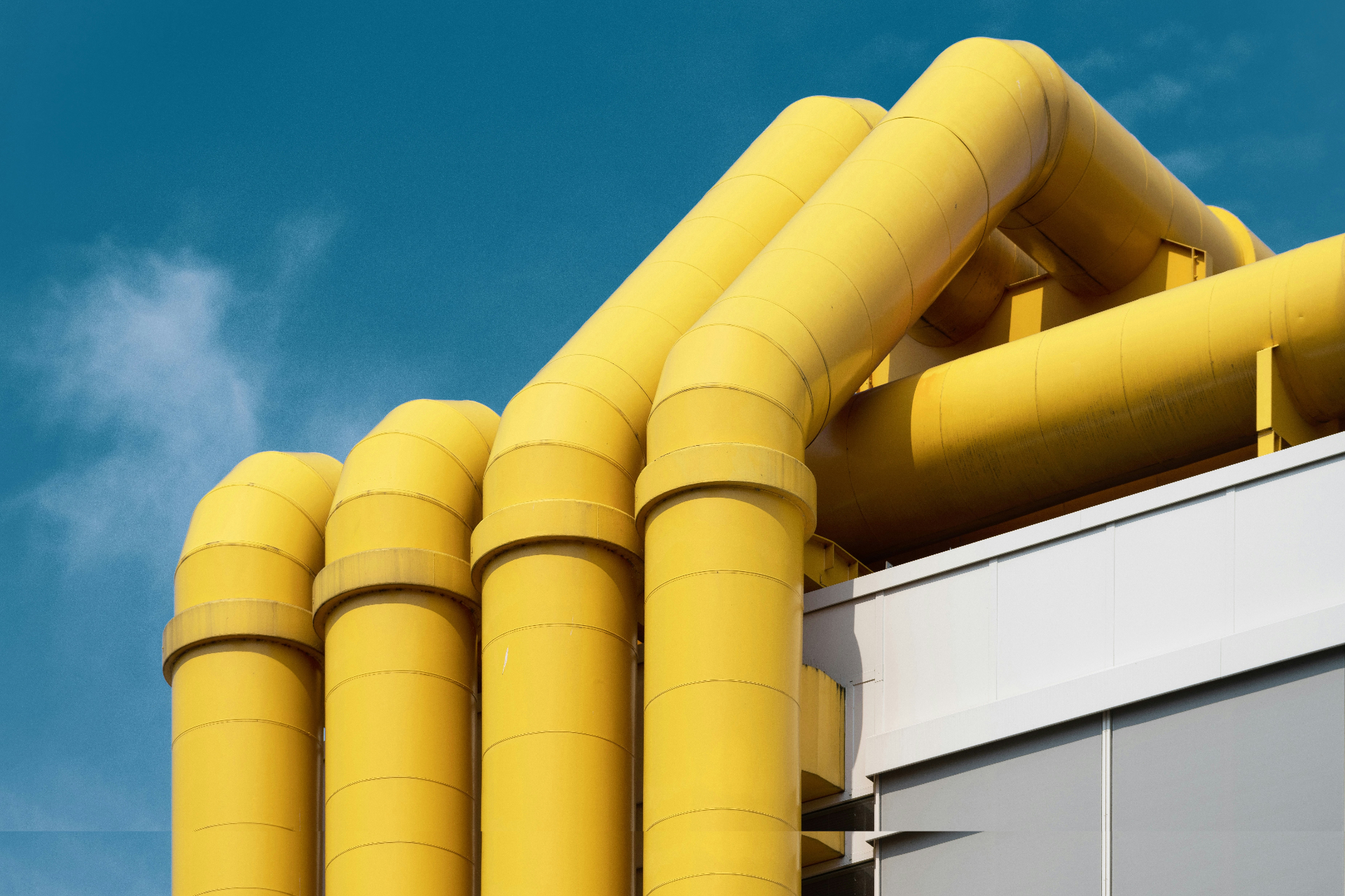 Yellow industrial pipes against blue sky